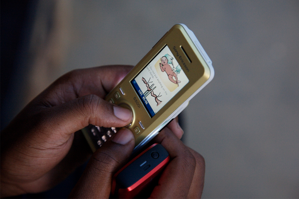 Adult hands using a maternal health app on a smart phone
