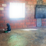 School Support Officer conducting a pupil assessment in an empty classroom in Northern Nigeria