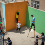 Syrian refugee children learn skills on the rooftop at Mardin Circus school next to brightly colored walls