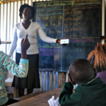 Teacher administering a vision test in a rural African school (Kenya)